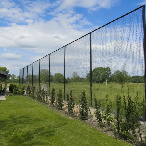Ballenvangernet voor golf langs een golfbaan met hoge zwarte staanders en fijnmazig net