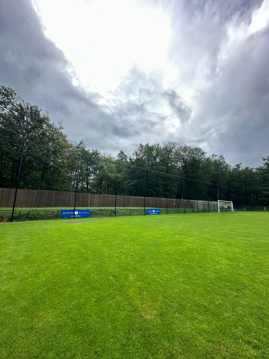 Ballenvanger van 7 meter hoog geplaatst bij trainingscomplex in Hoenderloo 4 Zwart geknoopt PE-net van de ballenvanger in Hoenderloo