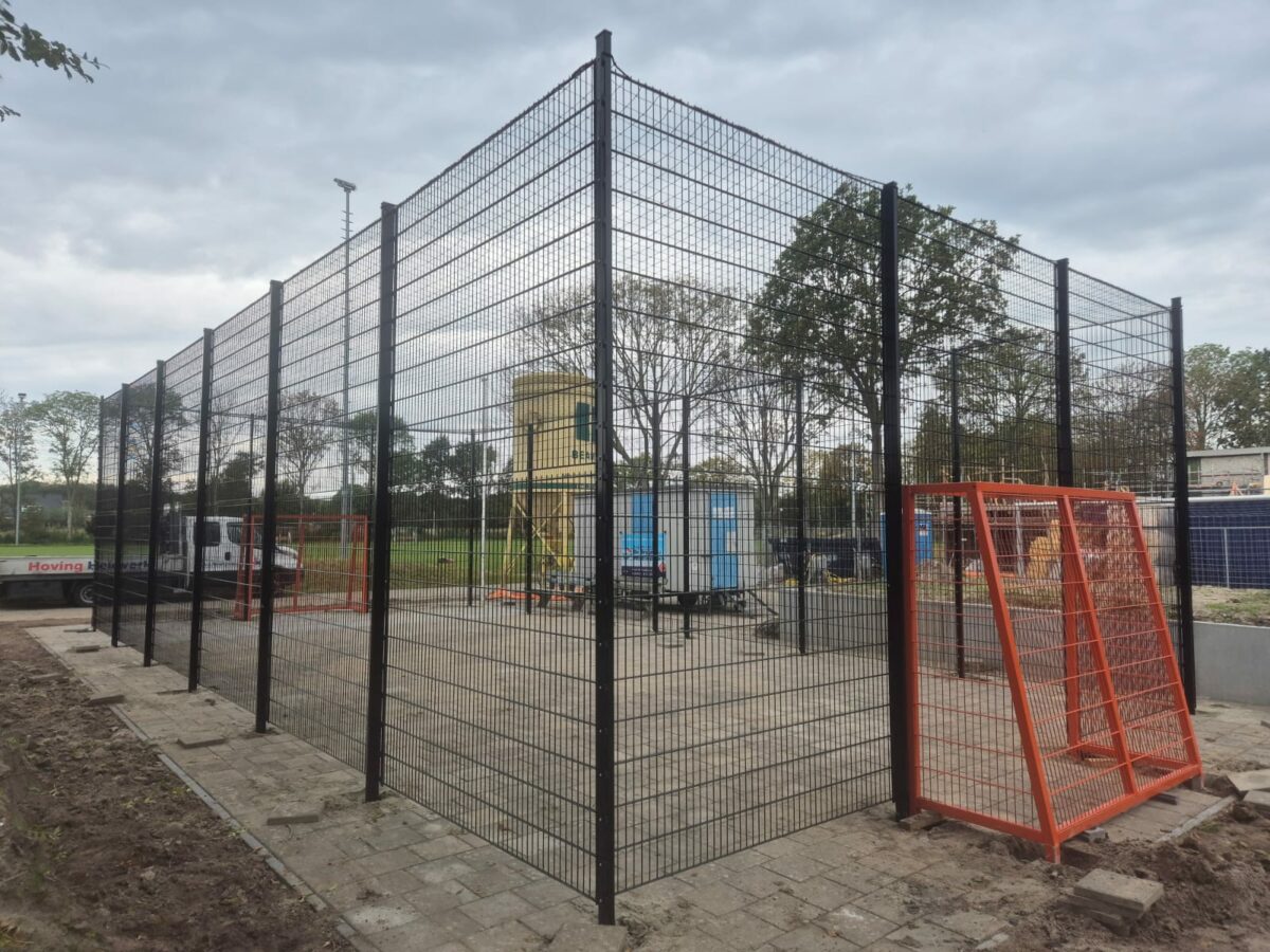 Twee maatwerk pannakooien gerealiseerd in Alkmaar en Rockanje 5 Zwarte pannakooi bij VV Rockanje met hoge wanden, netoverspanning en oranje voetbaldoelen
