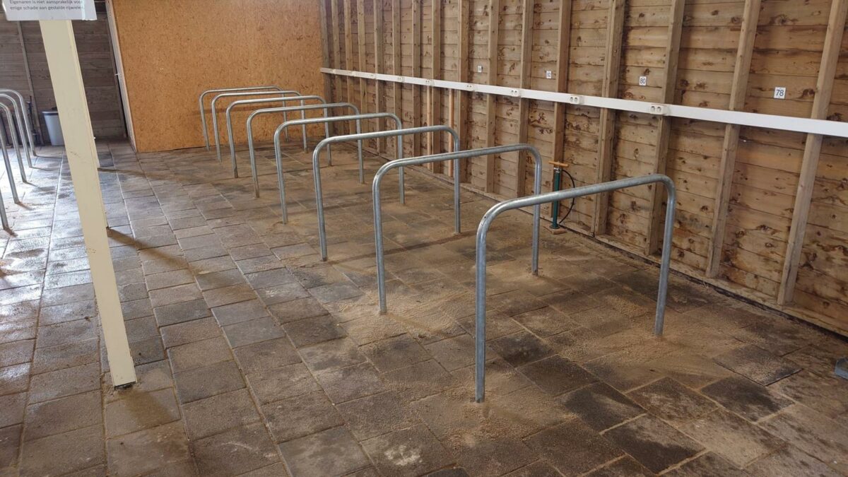 17 thermisch verzinkte fietsaanleunbeugels geplaatst in Den Helder 2 onde fietsaanleunbeugels van thermisch verzinkt staal, diameter 48 mm en afmetingen 1200 × 1200 mm, gemonteerd bij bestaande tegelbestrating in Den Helder.