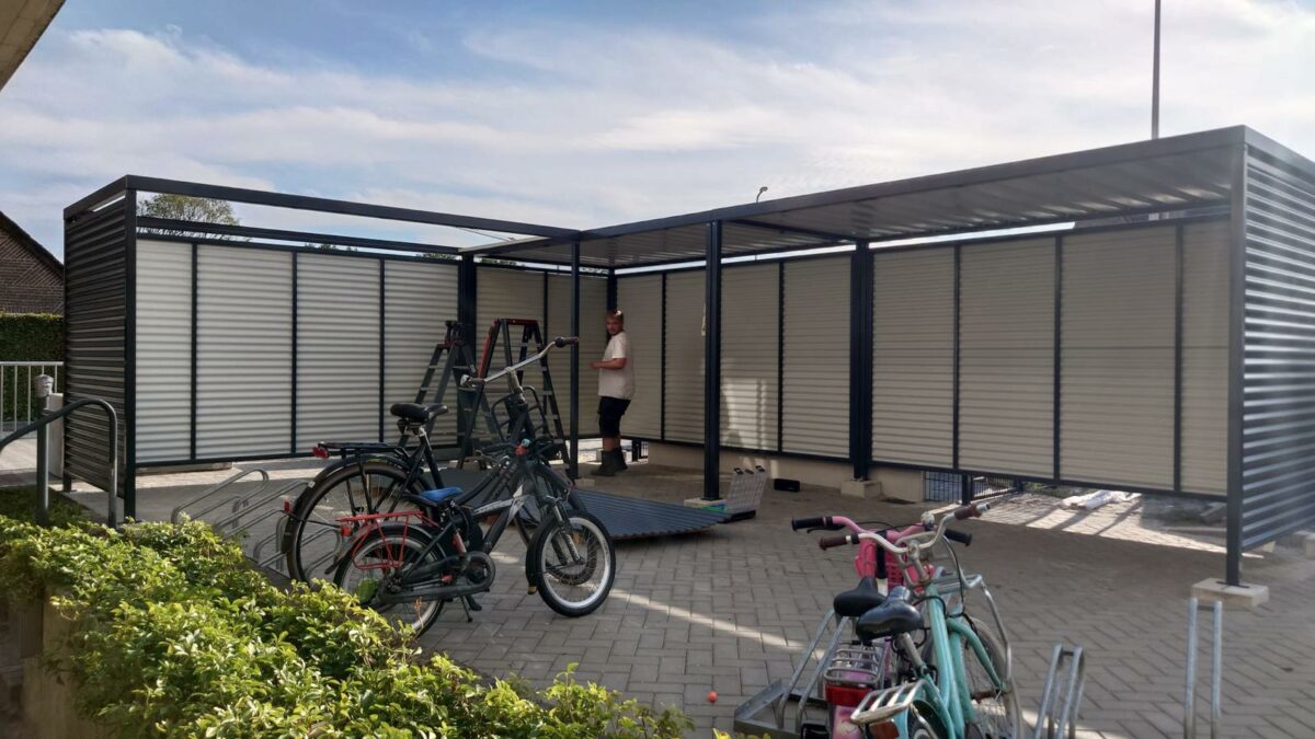 Maatwerk fietsoverkapping in Staphorst – Leipzig L-vorm met fietsoplaadpunten 1 Maatwerk fietsoverkapping Leipzig in L-vorm in Staphorst, uitgevoerd in RAL 7016 met fietsoplaadpunten