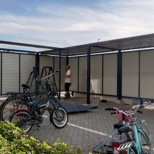 Fietsoverkapping Leipzig – Budgetvriendelijk & Schakelbaar 127 Maatwerk fietsoverkapping Leipzig in L-vorm in Staphorst, uitgevoerd in RAL 7016 met fietsoplaadpunten