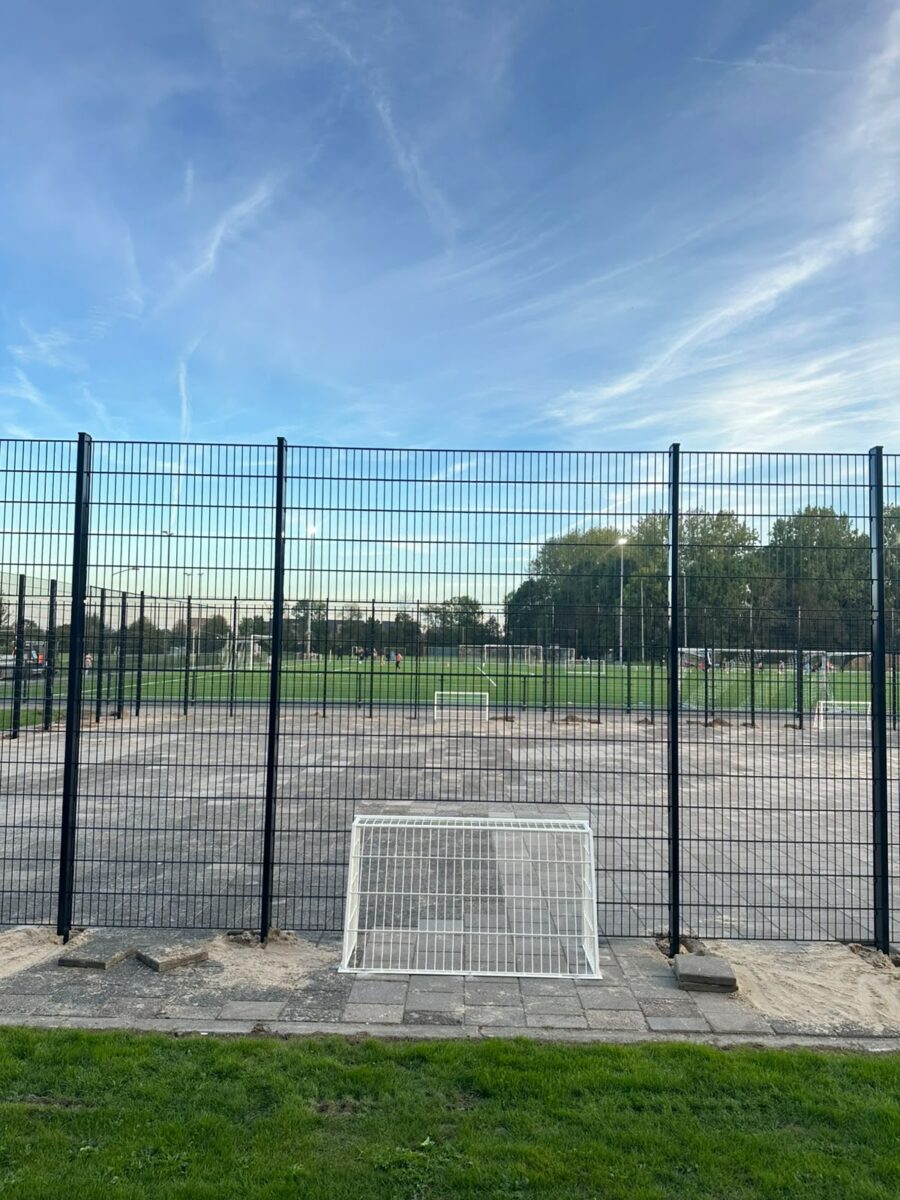 Pannakooi 28 × 18 meter geplaatst bij VV Sleeuwijk 3 Pannakooi bij VV Sleeuwijk met zwarte RAL 9005 constructie en zes witte voetbaldoelen