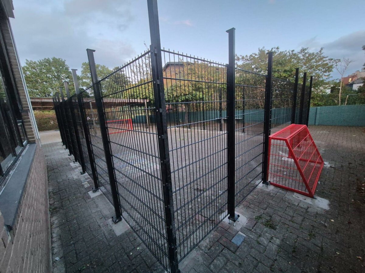 Twee maatwerk pannakooien geleverd en gemonteerd in Genk en bij Delfland 3 Maatwerk pannakooi bij De Padvinder in Genk, uitgevoerd in RAL 9005 met 2 meter hoge wanden, staanders van 2,40 meter en rode voetbaldoelen.